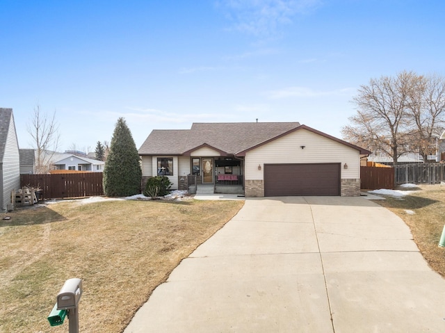 ranch-style home with fence, a front yard, roof with shingles, a garage, and driveway