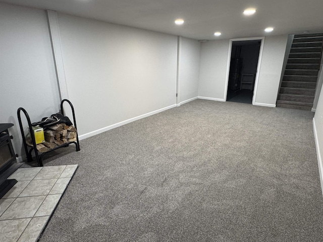 finished below grade area featuring stairs, recessed lighting, baseboards, and light carpet