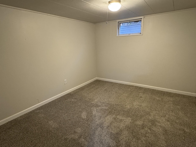 below grade area with baseboards and dark colored carpet