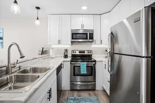 80 Twin Oaks Shr Unit 34, Bottineau, ND 58318 - kitchen with white cabinets, a sink, stainless steel appliances, and wood finished floors