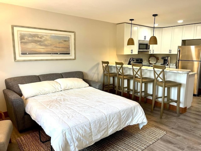 80 Twin Oaks Shr Unit 34, Bottineau, ND 58318 - bedroom with light wood-style flooring, recessed lighting, and freestanding refrigerator