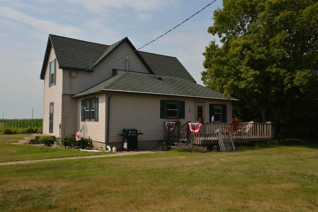 back of house with a lawn, a shingled roof, and a deck