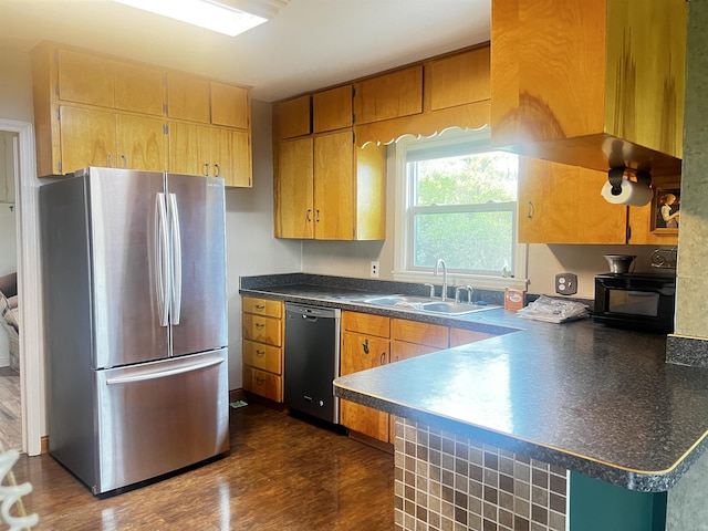 kitchen featuring a sink, dark countertops, dishwasher, freestanding refrigerator, and black microwave