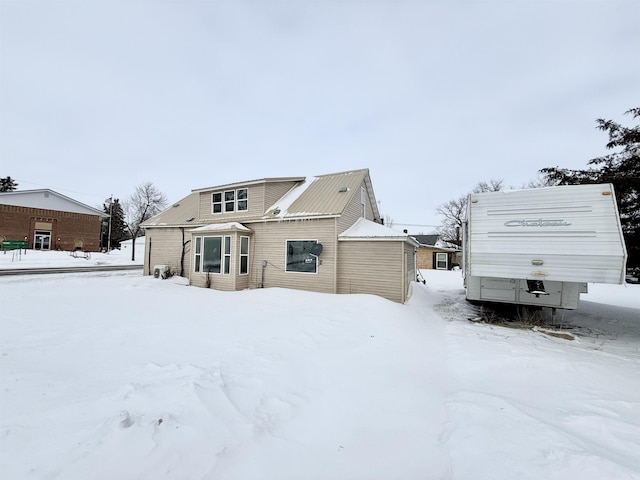 view of snow covered rear of property