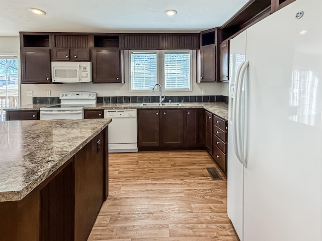 kitchen featuring a sink, open shelves, light wood-type flooring, and white appliances