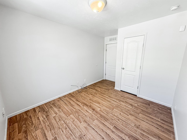 unfurnished bedroom with baseboards, light wood-style floors, and visible vents