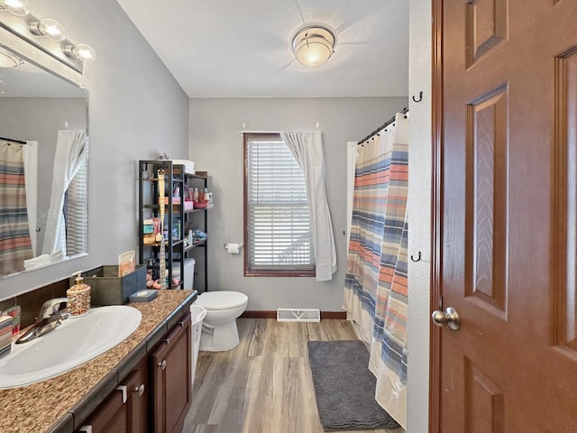 12780 153rd St, Sawyer, ND 58781 - bathroom with visible vents, baseboards, toilet, vanity, and wood finished floors