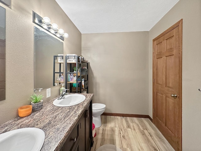 12780 153rd St, Sawyer, ND 58781 - bathroom featuring toilet, wood finished floors, a sink, and baseboards