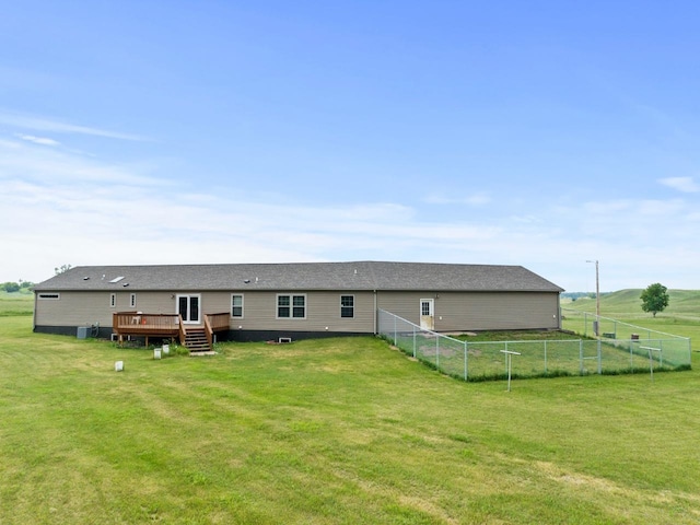 12780 153rd St, Sawyer, ND 58781 - rear view of house with roof with shingles, a yard, a wooden deck, and fence