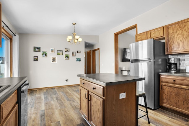 kitchen featuring dark countertops, light wood-type flooring, freestanding refrigerator, and dishwasher