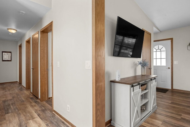 hallway featuring baseboards and dark wood-style floors