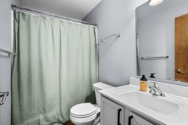 bathroom with toilet, curtained shower, and vanity