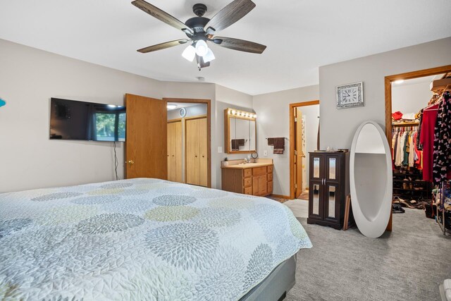 1419 17 1/2 Ave, Minot, ND 58701 - bedroom with a closet, ensuite bathroom, a ceiling fan, a walk in closet, and light colored carpet