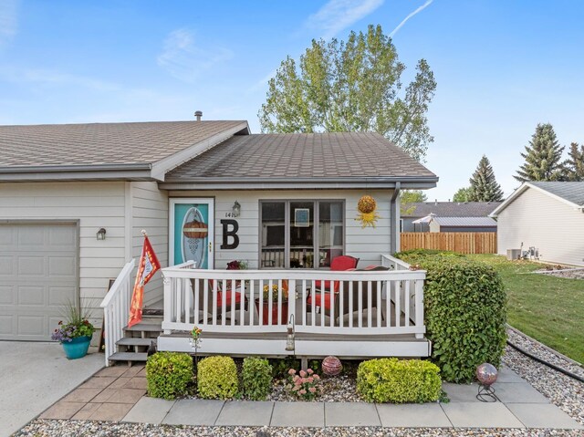 1419 17 1/2 Ave, Minot, ND 58701 - view of front of property with a garage, fence, and a shingled roof