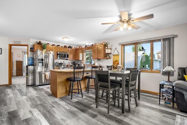 1419 17 1/2 Ave, Minot, ND 58701 - dining room with baseboards, a ceiling fan, and light wood-style floors