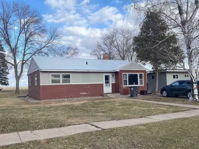 single story home featuring a front yard and metal roof