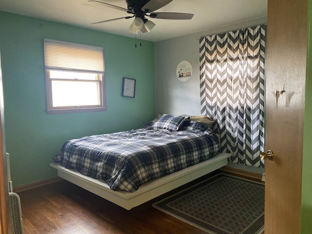 bedroom featuring baseboards, a ceiling fan, and wood finished floors