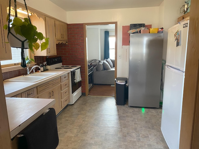 kitchen with white appliances, light countertops, and a sink