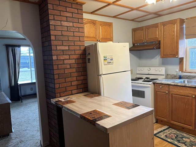 kitchen featuring arched walkways, a sink, white appliances, under cabinet range hood, and wooden counters