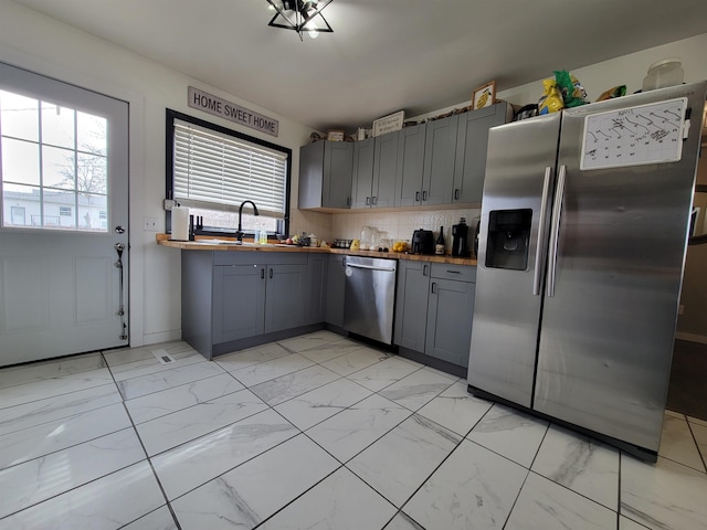 1425 9th St, Minot, ND 58701 - kitchen featuring gray cabinets, wood counters, appliances with stainless steel finishes, and marble finish floor