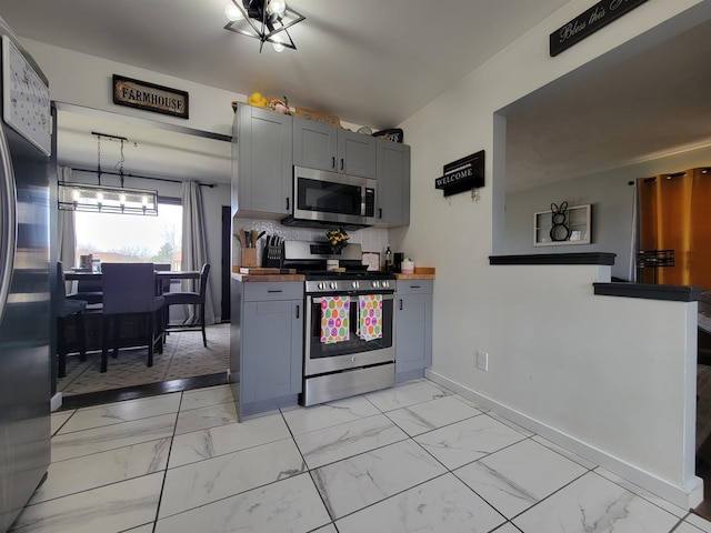 1425 9th St, Minot, ND 58701 - kitchen with stainless steel appliances, baseboards, gray cabinetry, and marble finish floor