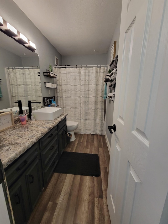 1425 9th St, Minot, ND 58701 - full bathroom with toilet, a shower with curtain, vanity, and wood finished floors