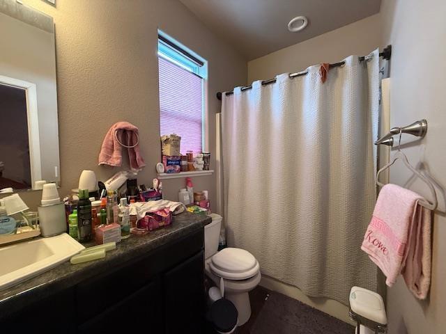 38 Mulberry Loop, Minot, ND 58703 - bathroom featuring vanity, curtained shower, and toilet