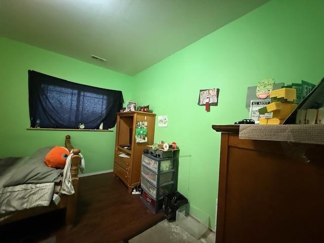 38 Mulberry Loop, Minot, ND 58703 - bedroom with visible vents, baseboards, and wood finished floors