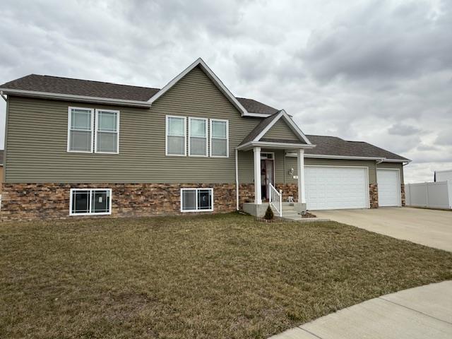 38 Mulberry Loop, Minot, ND 58703 - view of front of property featuring an attached garage, a front lawn, and concrete driveway