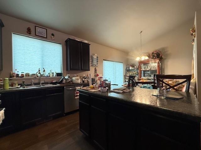 38 Mulberry Loop, Minot, ND 58703 - kitchen with dark countertops, dishwasher, dark cabinetry, a sink, and dark wood-type flooring