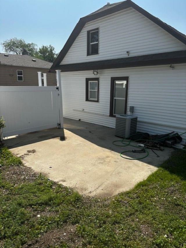 911 NE 9th Ave, Minot, ND 58701 - back of property featuring central AC and a patio