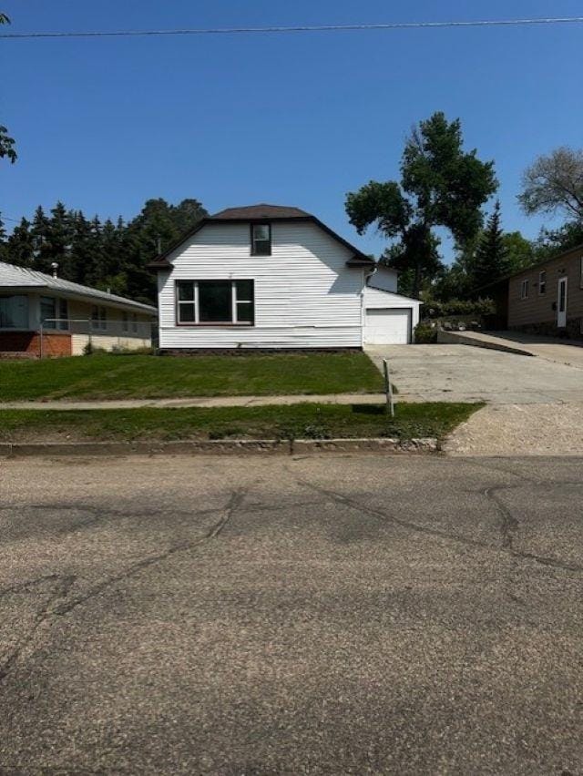 911 NE 9th Ave, Minot, ND 58701 - view of home's exterior featuring asphalt driveway