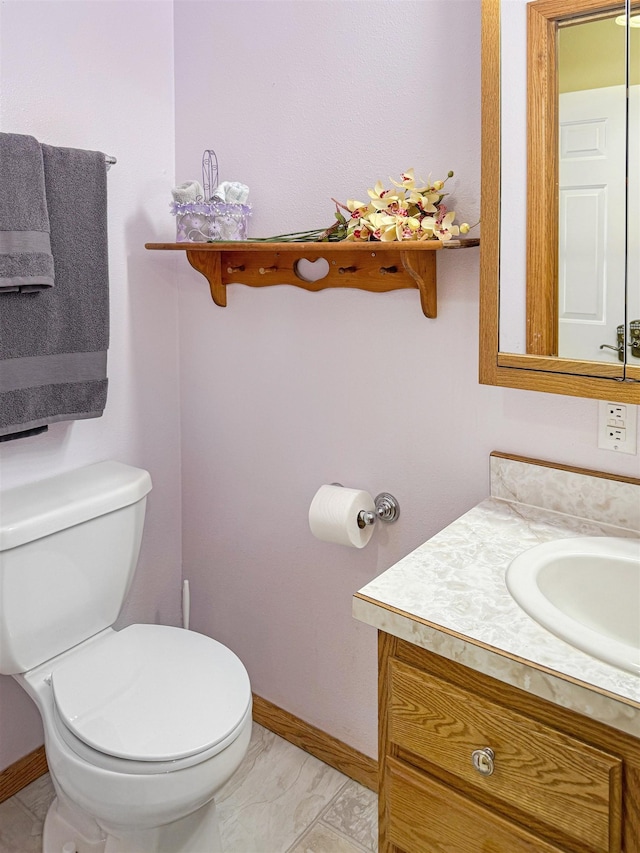812 15 1/2 Ave SE, Minot, ND 58701 - bathroom featuring baseboards, vanity, marble finish floor, and toilet