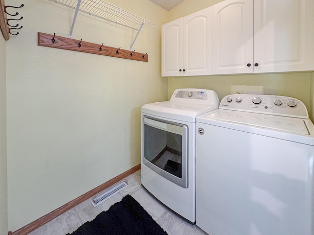 812 15 1/2 Ave SE, Minot, ND 58701 - washroom featuring cabinet space, visible vents, washing machine and clothes dryer, and baseboards