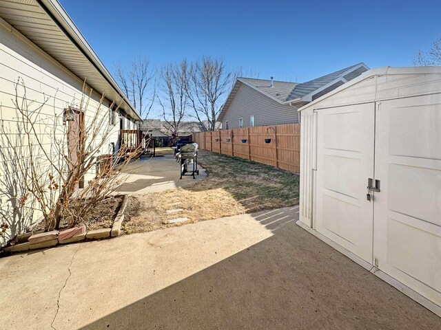 812 15 1/2 Ave SE, Minot, ND 58701 - view of yard with a storage unit, an outbuilding, a fenced backyard, and a patio