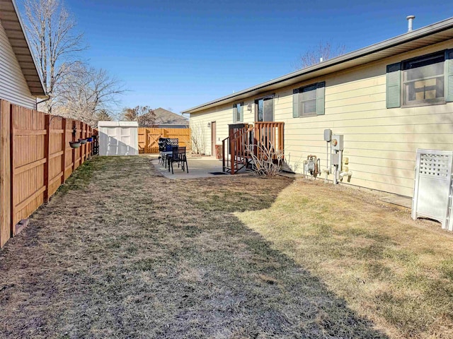 812 15 1/2 Ave SE, Minot, ND 58701 - rear view of house featuring a fenced backyard, a yard, a patio area, an outdoor structure, and a storage unit