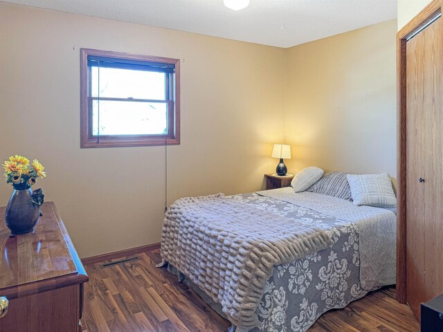 812 15 1/2 Ave SE, Minot, ND 58701 - bedroom featuring visible vents, baseboards, wood finished floors, and a closet