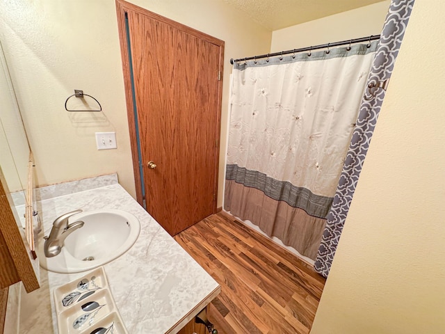 812 15 1/2 Ave SE, Minot, ND 58701 - full bath featuring a shower with curtain, wood finished floors, a textured ceiling, and vanity