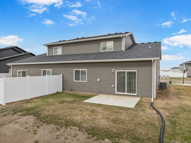 rear view of house with fence, central AC unit, a yard, and a patio