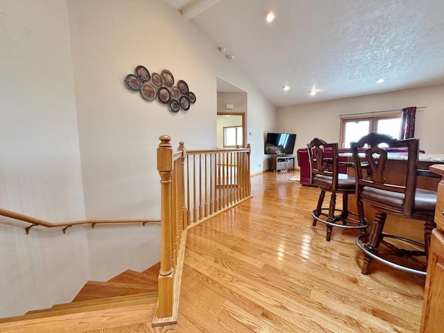 interior space with baseboards, recessed lighting, wood finished floors, and vaulted ceiling