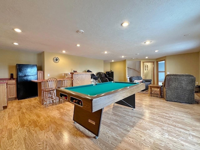 playroom featuring light wood-type flooring, billiards, and a textured ceiling