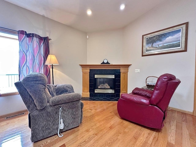 living room with recessed lighting, wood finished floors, a fireplace, baseboards, and visible vents