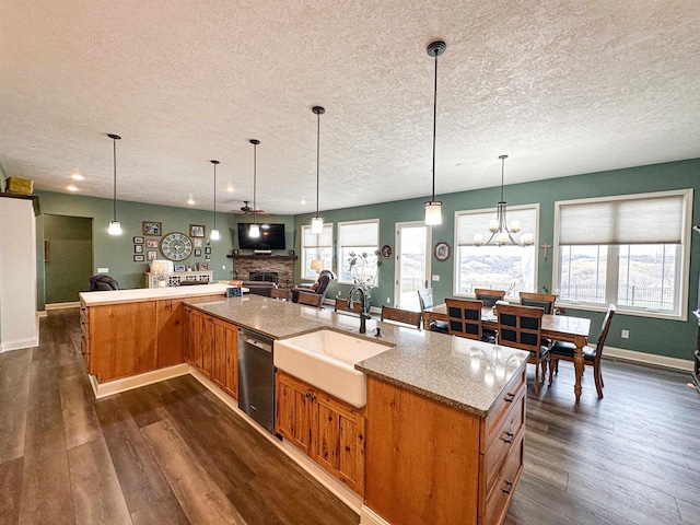 kitchen featuring a textured ceiling, dishwashing machine, and a sink