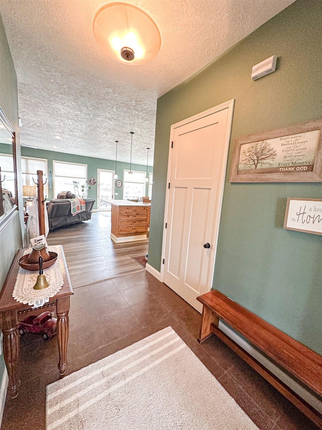 corridor featuring a textured ceiling and tile patterned flooring