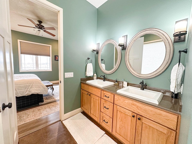 ensuite bathroom with ceiling fan, ensuite bath, double vanity, and a sink