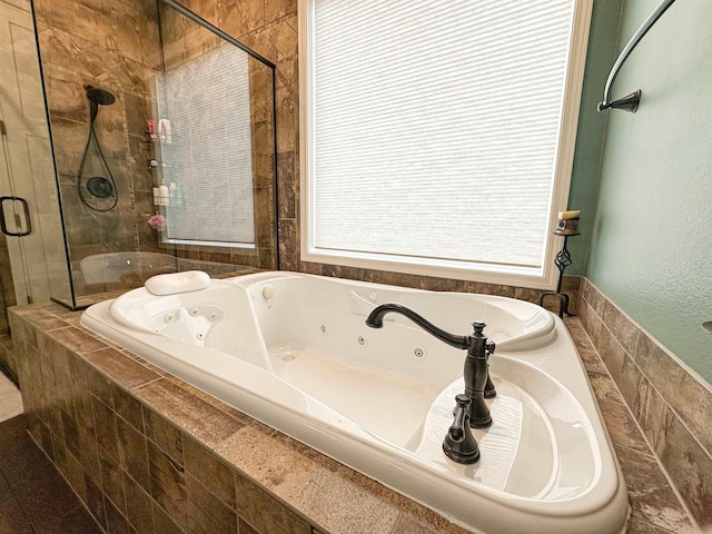 full bathroom featuring a shower stall and a jetted tub