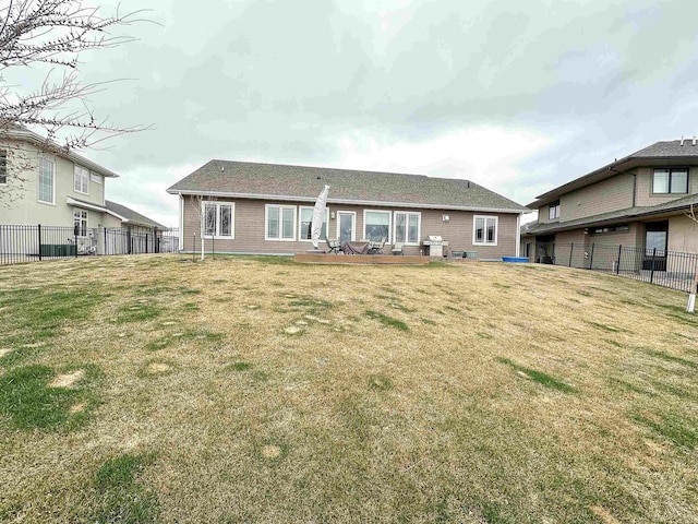 rear view of house featuring a fenced backyard and a yard