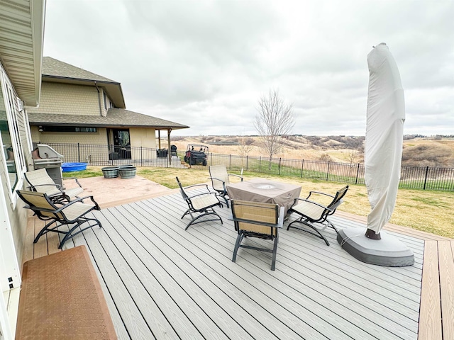 deck featuring a lawn, outdoor dining space, a patio area, and a fenced backyard
