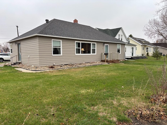 402 Brewster St, Harvey, ND 58341 - back of property featuring a chimney, a shingled roof, and a yard