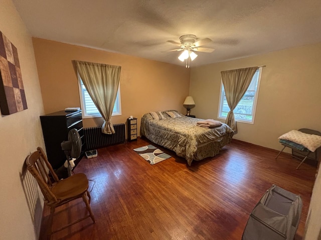 402 Brewster St, Harvey, ND 58341 - bedroom featuring radiator, a ceiling fan, and wood finished floors